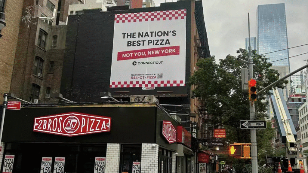 Billboard in NYC reading “Connecticut pizza wins. NYC takes the L.” promoting Connecticut tourism in 2025